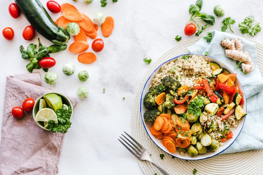 A bowl of quinoa topped with roasted broccoli, carrots, courgette, peppers and Brussels sprouts